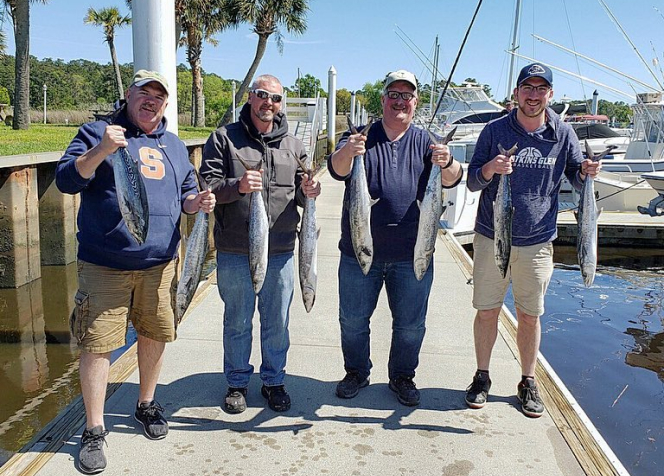 four men holding their catch from their trip along the myrtle beach area coast